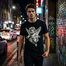 Мъж в черна тениска с изображение на Ангел, носеща Двойка Ангели - 15% ОТСТЪПКА, в градска среда.